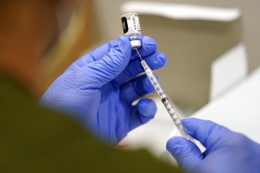 Seorang petugas kesehatan di Amerika Serikat mengisi jarum suntik dengan vaksin Pfizer Covid-19. FDA disebut perlu mempertimbangkan kembali rencana pemberian vaksin Covid-19 yang diulang tiap tahun.