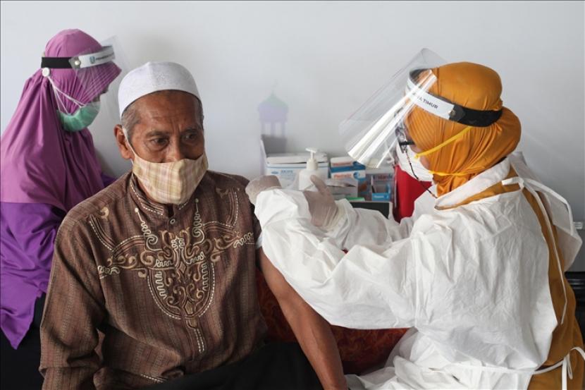 Seorang petugas kesehatan menyuntikkan vaksin virus korona kepada pengurus masjid dan pemuka agama Islam di Masjid Al Akbar di Surabaya, Provinsi Jawa Timur, Indonesia pada tanggal 23 Maret 2021. Vaksinasi dilakukan untuk mengekang penyebaran virus korona (Covid-19) menjelang bulan suci Ramadhan umat Islam.