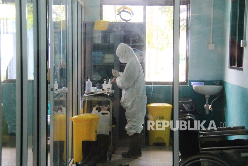 Seorang petugas medis bersiap memakai alat pelindung diri untuk memeriksa pasien suspect virus Corona di ruang isolasi instalasi paru Rumah Sakit Umum Daerah (RSUD) Dumai di Dumai, Riau, Jumat (6/3/2020).(Antara/Aswaddy Hamid)