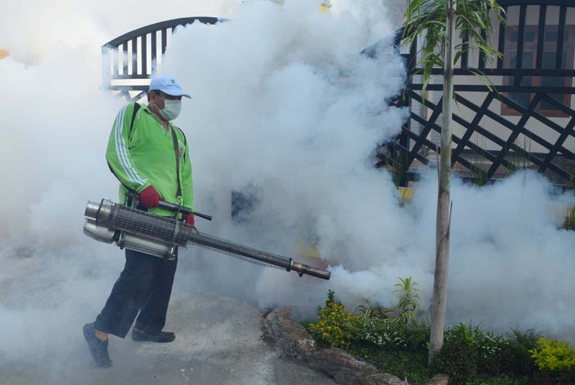  Seorang petugas melakukan pengasapan (fogging) untuk membasmi nyamuk demam berdarah.