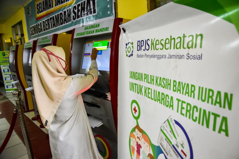 Seorang petugas membantu memasukkan data pasien pengguna BPJS Kesehatan di mesin anjungan pengantrean mandiri di RSUD Arifin Achmad, Kota Pekanbaru, Riau, Selasa (14/7/2020).(Ilustrasi)