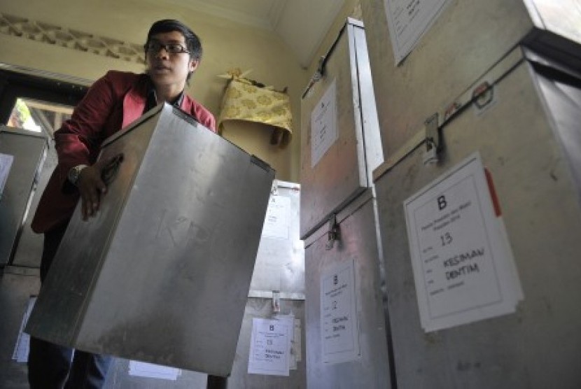 Seorang petugas membawa kotak yang berisi surat suara dari tempat pemungutan suara (TPS) saat rekapitulasi perolehan suara Pemilu Presiden 2014 