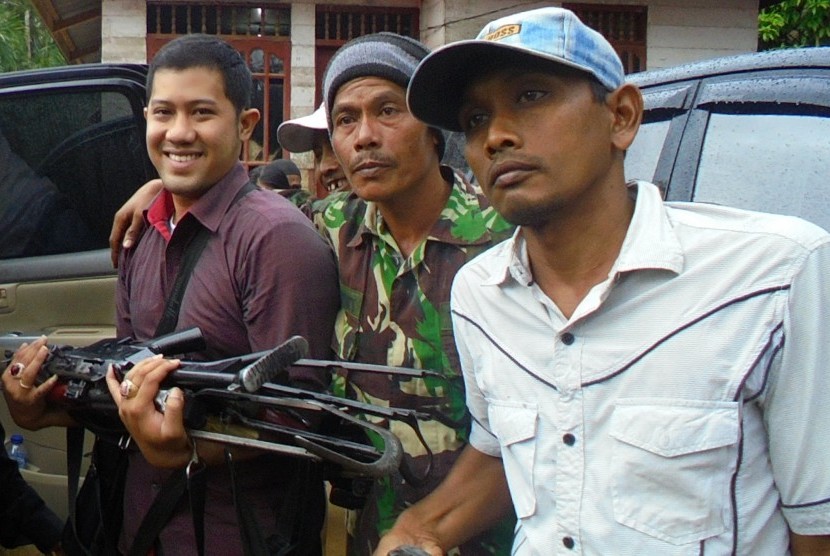 Seorang petugas membawa senjata milik kelompok Nurdin alias Din Minimi setelah diserahkan kepada pihak berwajib di Desa Ladang Baro, Kecamatan Julok, Aceh Timur, Aceh, Selasa (29/12).