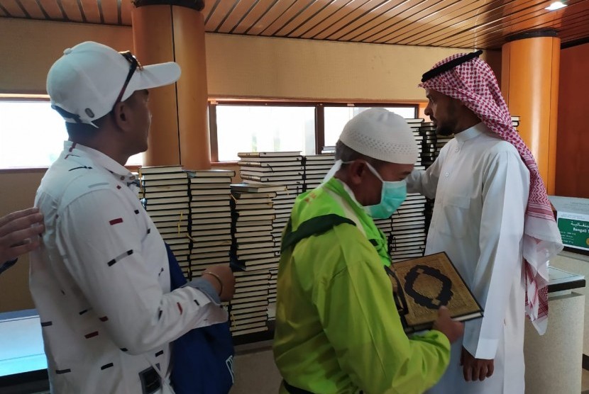 Seorang petugas memberikan Al-Quran kepada jamaah haji yang berkunjung ke Pusat Percetakan Al-Quran di Madinah, Selasa (16/7). Al-Quran dicetak di tempat ini sebanyak 18 juta eksemplar dan disebar ke 76 negara di dunia. 