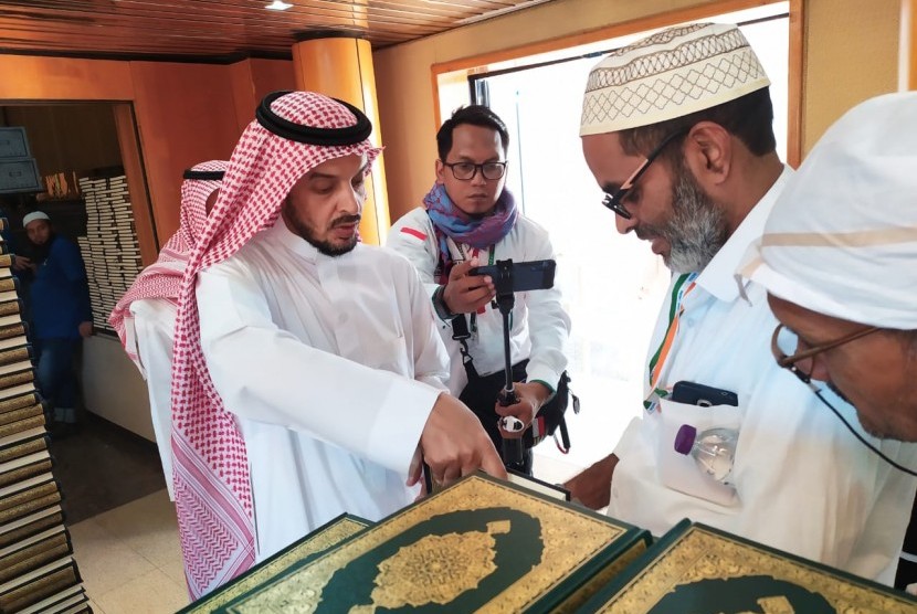 Seorang petugas memberikan Al-Quran kepada jamaah haji yang berkunjung ke Pusat Percetakan Al-Quran di Madinah, Selasa (16/7). Al-Quran dicetak di tempat ini sebanyak 18 juta eksemplar dan disebar ke 76 negara di dunia. 