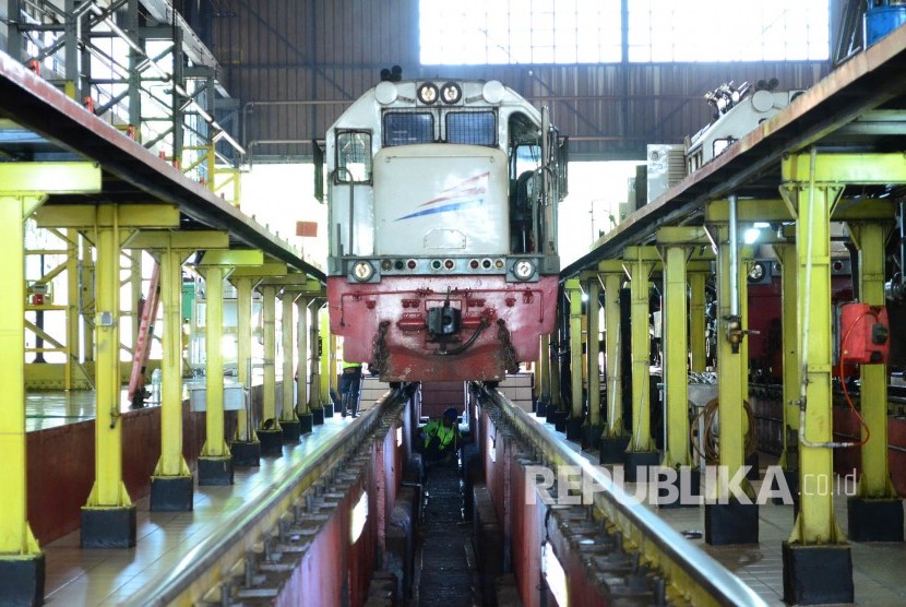 Seorang petugas memeriksa bagian kolong lokomotif, di Depo Lokomotif PT Kereta Api Indonesia (PT KAI) DAOP 2 Bandung, Jumat (9/6).