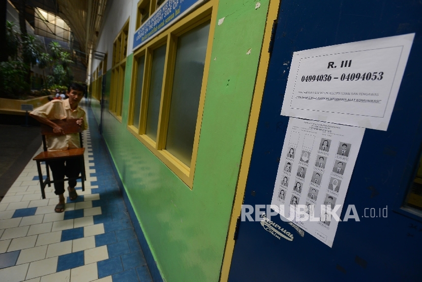 Seorang petugas mempersiapkan bangku untuk ujian nasional di SMA Perguruan Cikini, Jakarta, Ahad (3/4).Republika/Raisan Al Farisi