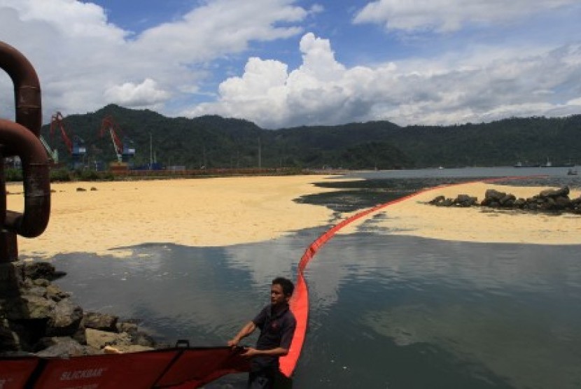 Seorang petugas menarik plastik pembatas (oil boom) untuk menghambat tersebarnya minyak sawit mentah atau crude palm oil (CPO) milik PT Wira Innomas yang tumpah di perairan Teluk Bayur, Padang, Sumatra Barat, Kamis (28/9). Menurut pihak PT Wira Innomas, minyak sawit yang tumpah ke laut kurang lebih 50 ton. Hal tersebut disebabkan terjadinya kebocoran pada pipa penyambung dari tangki penimbun.