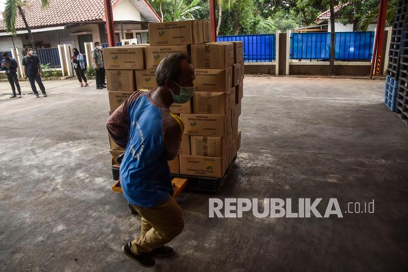 Seorang petugas menata barang di gudang logistik Gedung Departemen Sosial, Bekasi, Jawa Barat, Selasa (14/12). Supply Chain Indonesia (SCI) memprediksi pertumbuhan logistik pada 2022 tipis. 
