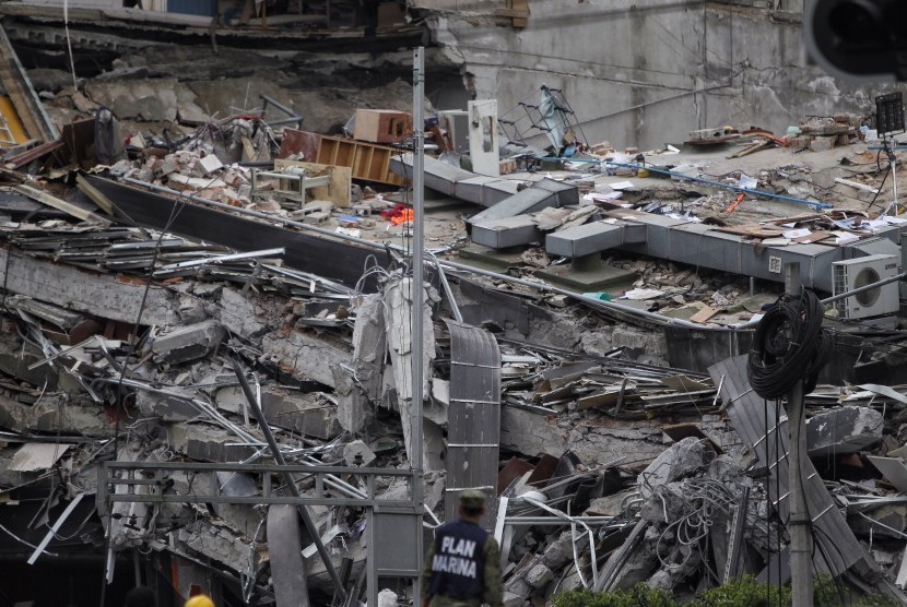 Seorang petugas mengamati tumpukan puing yang merupakan lantai bangunan sambil terus mencari korban selamat menyusul gempa 7,1 skala richter yang terjadi di Meksiko, Selasa (19/9).
