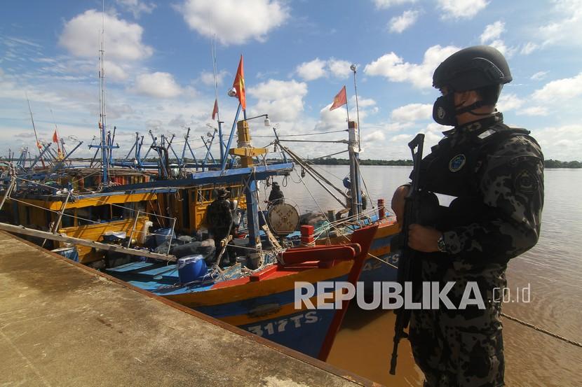 Seorang petugas mengawasi kapal ikan ilegal berbendera Vietnam (ilustrasi).
