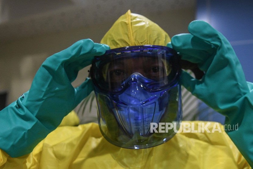 Seorang petugas mengenakan pakaian pelindung lengkap antisipasi penularan virus corona.