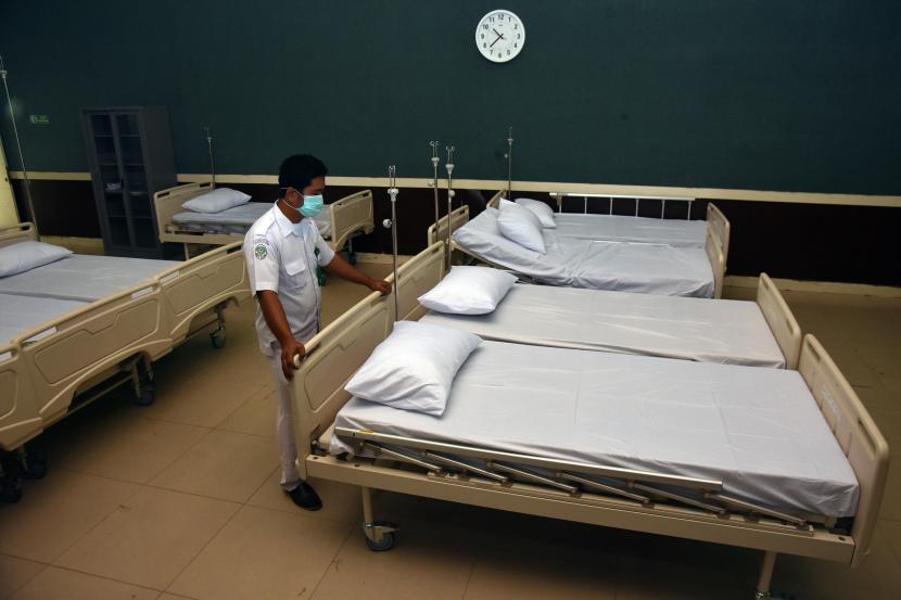 Seorang petugas menyiapkan tempat tidur untuk pasien Covid-19. 