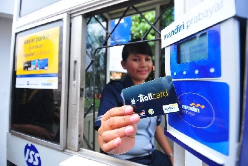 Seorang petugas parkir ISS Parking Management menunjukkan kartu e-toll Mandiri yang dapat digunakan untuk pembayaran biaya parkir dengan parkir ISS Parking di Jakarta.