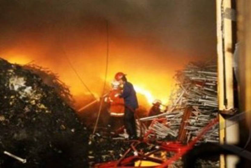 Seorang petugas pemadam kebakaran berupaya memadamkan jilatan api yang membakar sebuah gudang. (ilustrasi)