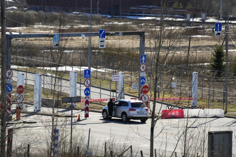 Seorang petugas penjaga perbatasan Rusia memeriksa sebuah mobil di titik penyeberangan perbatasan Pelkola di Imatra, Finlandia tenggara, Jumat, 14 April 2023.