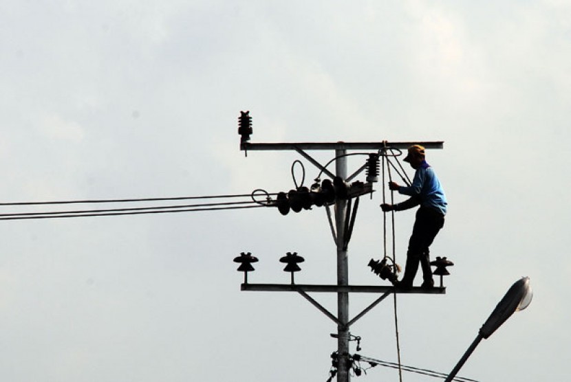 Seorang petugas PLN melakukan perbaikan instalasi jaringan listrik.