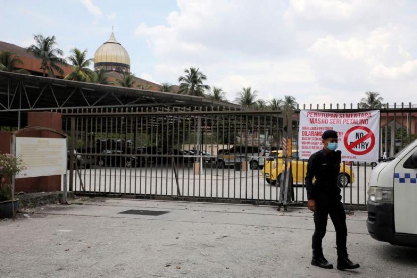 Seorang petugas polisi berjaga di depan Masjid Seri Petaling di Kuala Lumpur, Malaysia, 18 Maret 2020. Lebih dari setengah kasus virus corona di Malaysia berasal dari jamaah tabligh akbar di masjid tersebut.