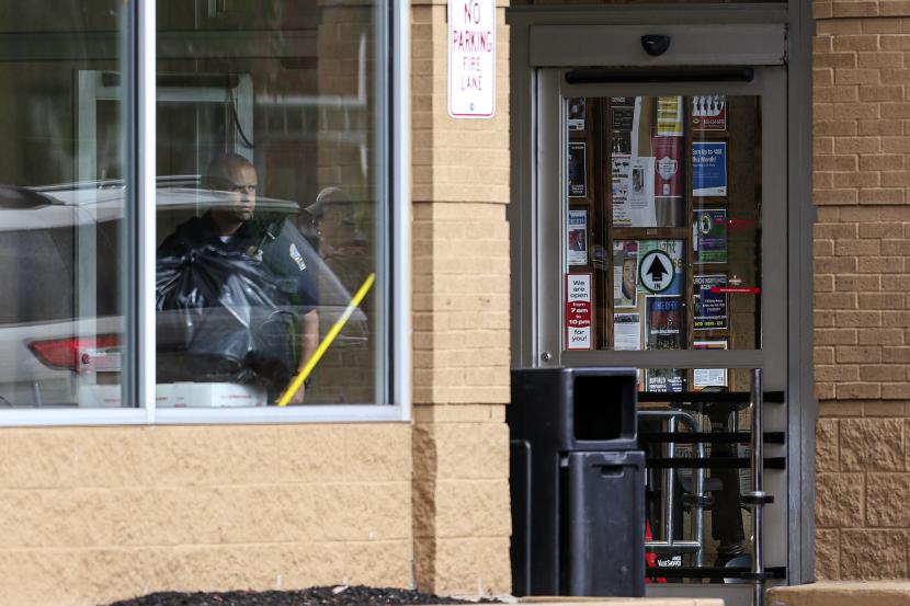 Seorang petugas polisi melihat ke luar jendela toko saat pihak berwenang menyelidiki penembakan di supermarket, Sabtu, 14 Mei 2022, di Buffalo, N.Y.