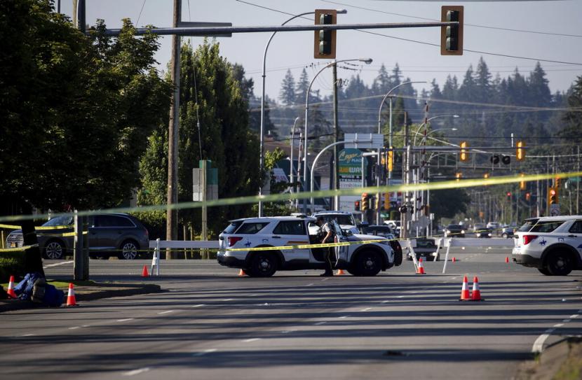 Seorang petugas RCMP berdiri di luar kendaraan di penghalang jalan di lokasi penembakan di Langley, British Columbia, Senin, 25 Juli 2022. Polisi Kanada melaporkan beberapa penembakan tunawisma Senin di pinggiran kota Vancouver dan mengatakan seorang tersangka ditahan. 