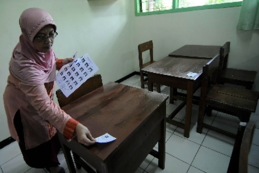 Seorang petugas sekolah menempelkan kartu peserta Ujian Nasional (UN) SMA/MA tahun pelajaran 2011/2012 di tiap-tiap ruang kelas di SMAN 70, Bulungan, Jakarta Selatan, Jumat (12/4). 