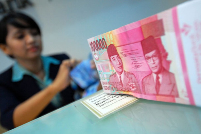  Program Bansos Bagi Pekerja Dinilai Jaga Pertumbuhan Ekonomi. Foto: Seorang petugas teller menghitung mata uang rupiah.    (ilustrasi)