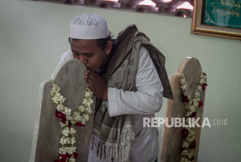 Seorang peziarah mencium nisan makam Habib Ali bin Muhammad Al Habsyi saat peringatan Haul ke-106, di Masjid Ar Riyadh, Pasar Kliwon, Solo, Jawa Tengah, Selasa (9/1). 