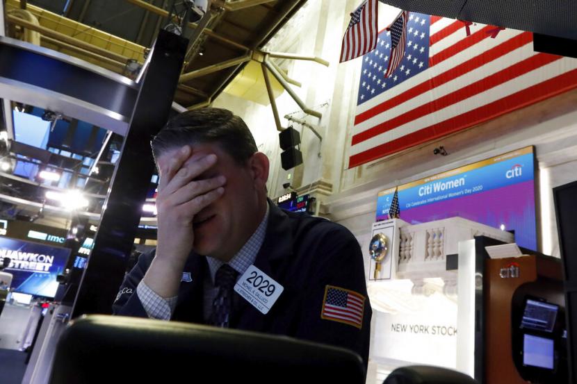 Seorang pialang saham beraktivitas di New York Stock Exchange, Senin (9/3). Kekhawatiran ketidakpastian global telah menghapus lebih dari lima triliun dolar AS dari nilai pasar S&P 500 dalam beberapa pekan terakhir. 