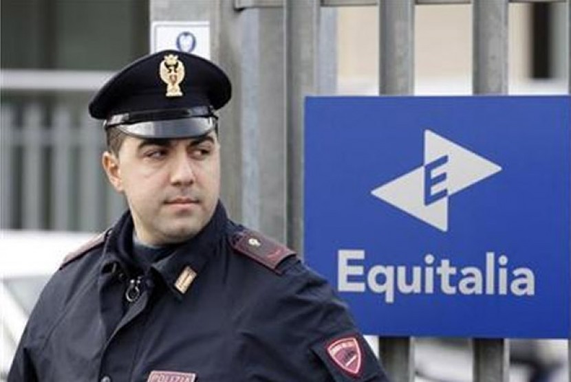 Seorang polisi berjaga di depan kantor lembaga pengumpul pajak Italia, Equitalia, di Kota Verona. 