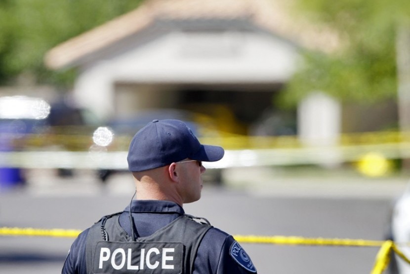 Seorang polisi berjaga di kompleks perumahan lokasi penembakan lima orang di Arizona, AS