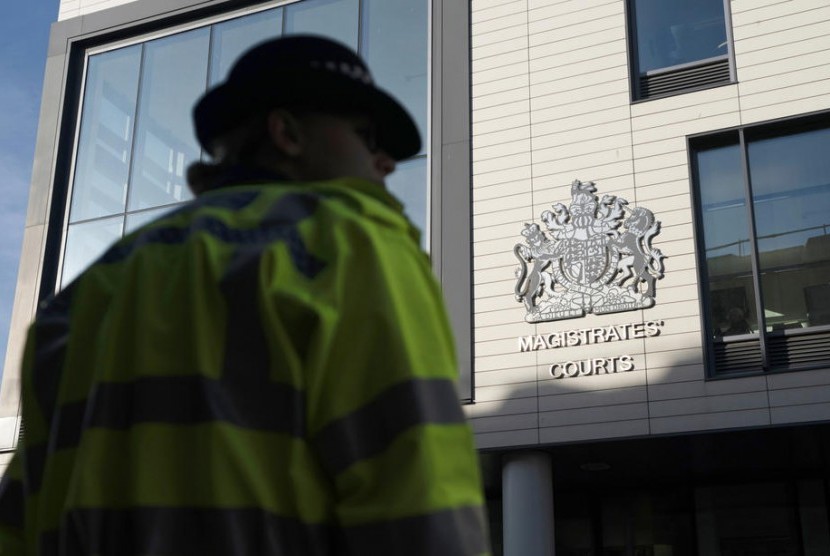 Seorang polisi berjaga di luar pengadilan Chelmsford Magistrates Court di Chelmsford, Essex, Inggris, Senin (28/10). Sopir truk Maurice Robinson (25 tahun) didakwa 39 pembunuhan dan tuduhan lain atas temuan 30 jenazah dalam truk.