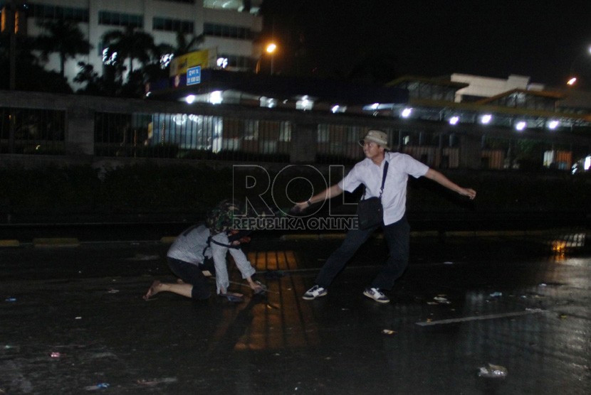  Seorang polisi berpakaian preman menahan seorang pengunjuk rasa yang menolak kenaikan BBM di depan Komplek Parlemen, Jakarta, Senin (17/6) malam.   (Republika/Yasin Habibi)