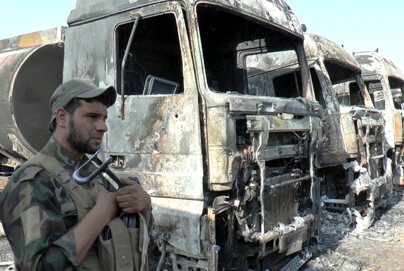 Seorang polisi Irak berdiri di sisi truk-truk yang terbakar di lokasi serangan bom bunuh diri di sebuah stasiun pembangkit di Kota Samara, sekitar 120 km sebelah utara Baghdad, Irak, pada 2 September 2017.  