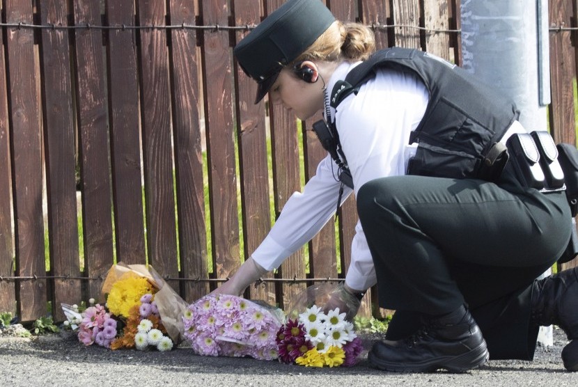 Seorang polisi meletakan bunga di lokasi terbunuhnya jurnalis Lyrca Mckee.