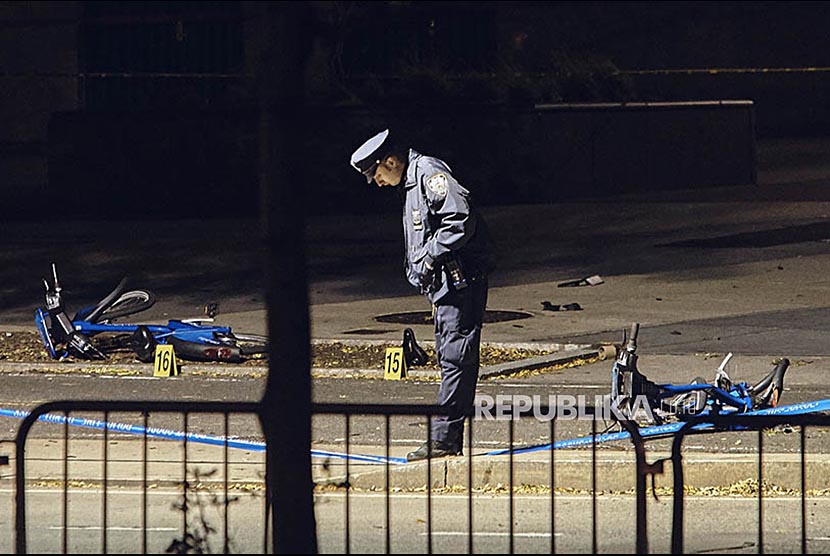 Seorang polisi memperhatikan sepeda yang rusak tertabrak pada peristiwa penyerangan di New York Cuty 