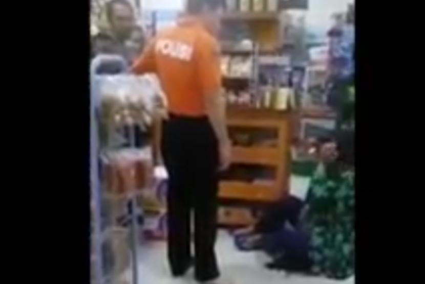 Adjunct Senior Comm. M Yusuf (orange suit), a mid-ranking officer in Bangka Belitung Police, scolds and kicks a woman in her head at a minimarket in Bangka Belitung.