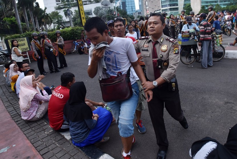Seorang Polisi mengamankan copet yang beraksi pada hari bebas kendaraan bermotor (HBKB) di Kawasan Bundaran HI Jakarta, Minggu (15/1). 
