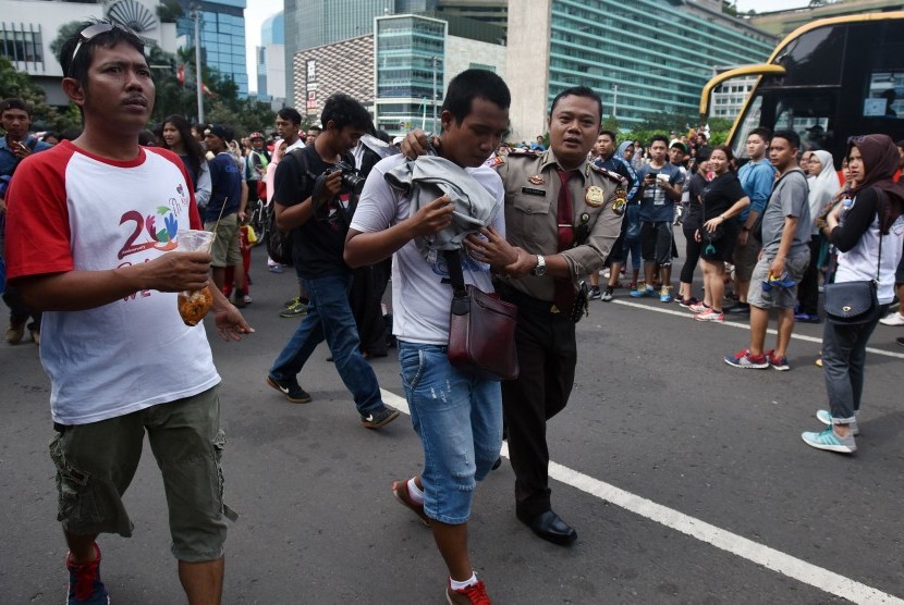 Seorang Polisi mengamankan copet yang beraksi pada hari bebas kendaraan bermotor (HBKB) di Kawasan Bundaran HI Jakarta, Minggu (15/1).