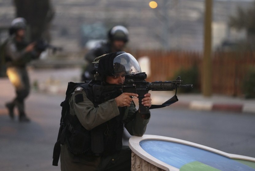 Seorang polisi perbatasan Israel membidik senjatanya selama bentrokan dengan warga Palestina di dekat pemukiman Yahudi Bet El, dekat kota Tepi Barat yang diduduki Ramallah.  