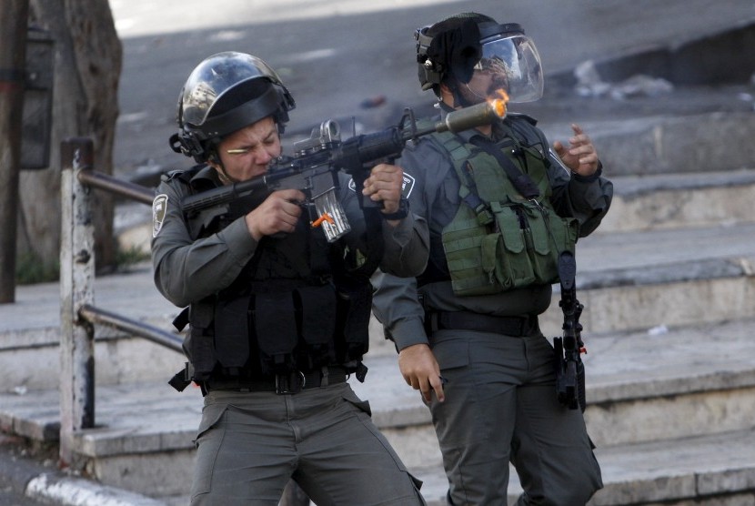 Seorang polisi perbatasan Israel menembakkan peluru karet di pengunjuk rasa Palestina dalam bentrokan di Yerusalem al-Aqsa, di kota Tepi Barat yang diduduki Hebron 29 September 2015.