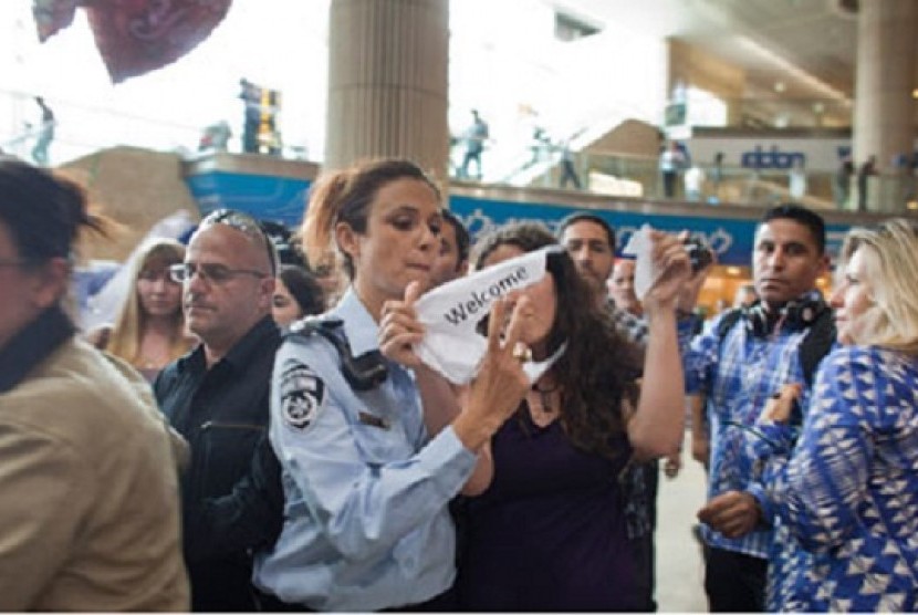 Seorang polwan Israel menangkap aktivis yang merampas spanduk bertuliskan 'Selamat Datang di Palestina' di Bandara Ben Gurion, Tel Aviv.