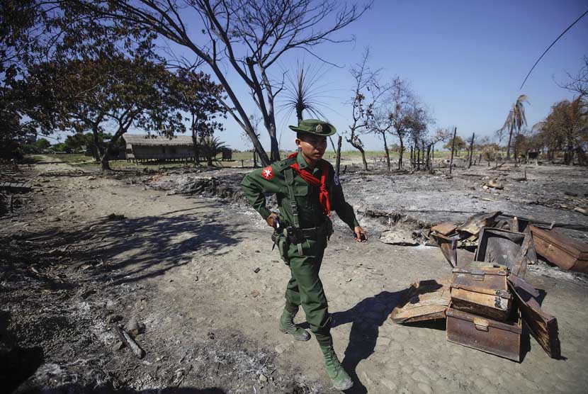 Seorang prajurit berjalan di tengah puing perkampungan Pauktaw yang dibakar dalam kekerasan baru-baru di Rakhine, Myanmar (Ilustrasi)