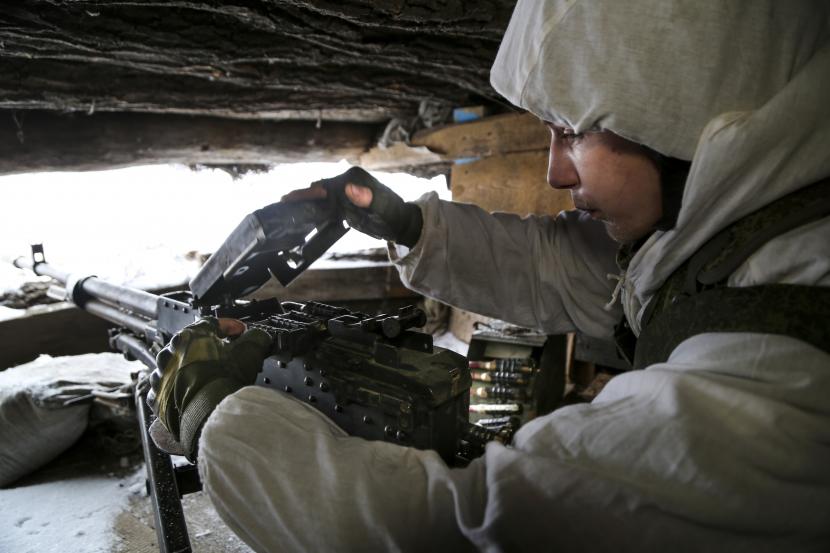 Seorang prajurit memeriksa senapan mesinnya di tempat perlindungan di wilayah yang dikuasai oleh militan pro-Rusia di garis depan dengan pasukan pemerintah Ukraina di Slavyanoserbsk, wilayah Luhansk, Ukraina timur, Selasa, 25 Januari 2022.