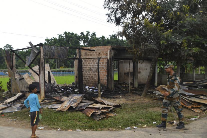 Seorang prajurit paramiliter berpatroli melewati sebuah toko yang terbakar di desa Rowa, sekitar 220 kilometer dari Agartala, di negara bagian Tripura, India, Rabu, 27 Oktober 2021. Ketegangan tinggi di beberapa bagian negara bagian Tripura pada Jumat setelah serangkaian serangan terhadap minoritas Muslim. Serangan itu sebagai pembalasan atas kekerasan terhadap umat Hindu di perbatasan Bangladesh awal bulan ini. Polisi mengatakan setidaknya satu masjid, beberapa toko dan rumah milik Muslim dirusak sejak Selasa. 