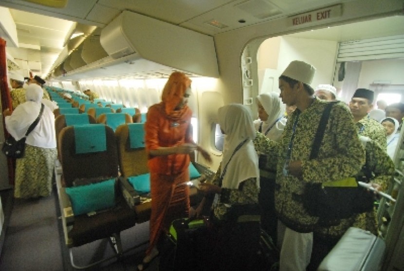 Seorang pramugari membimbing para calon jamaah umrah di kabin pesawat dalam penerbangan langsung menuju Jeddah.