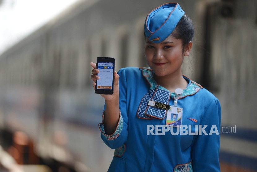 Seorang pramugari menunjukan aplikasi untuk memesan tiket kereta api online di dalam gerbong kereta Jayabaya tujuan Malang di Stasiun Pasar Senen, Jakarta, 