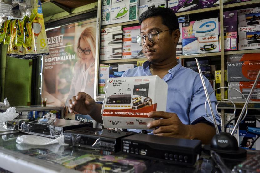 Seorang pramuniaga mengecek dekoder televisi atau set top box (STB) yang dijual di salah satu toko elektronik di Tangerang Selatan, Banten, Jumat (28/10/2022). Kominfo akan menghentikan siaran televisi analog atau Analog Switch Off (ASO) di Jabodetabek pada 2 November 2022.
