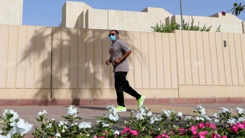 Seorang pria Arab Saudi jogging dengan mengenakan masker selama periode lockdown atau karantina wilayah akibat Covid-19.