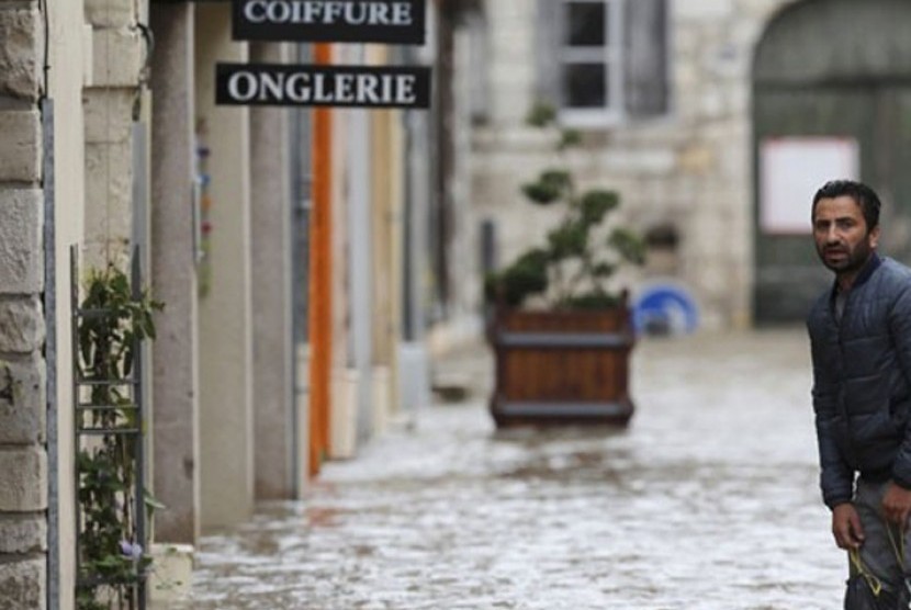 Seorang pria berjalan di tengah jalanan banjir setelah terjadi hujan lebat di Montargis, Loiret, Prancis, Rabu (1/6/2016). (REUTERS/Christian Hartmann )