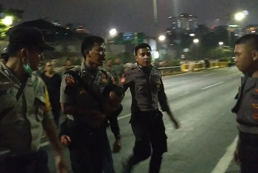 Seorang pria berpakaian hitam ditangkap petugas di Jalan Gatot Subroto, Jakarta, Rabu (25/9) malam.